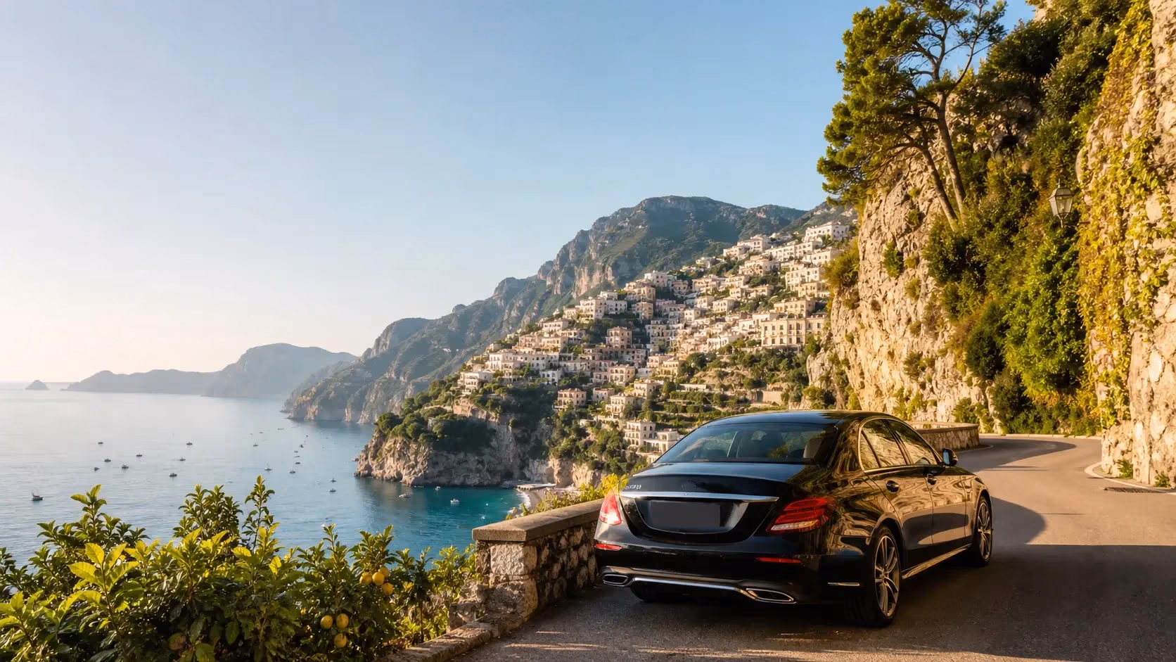 "Auto Mercedes Benz nera con autista privato a un belvedere della Costiera Amalfitana sopra Positano al mattino"