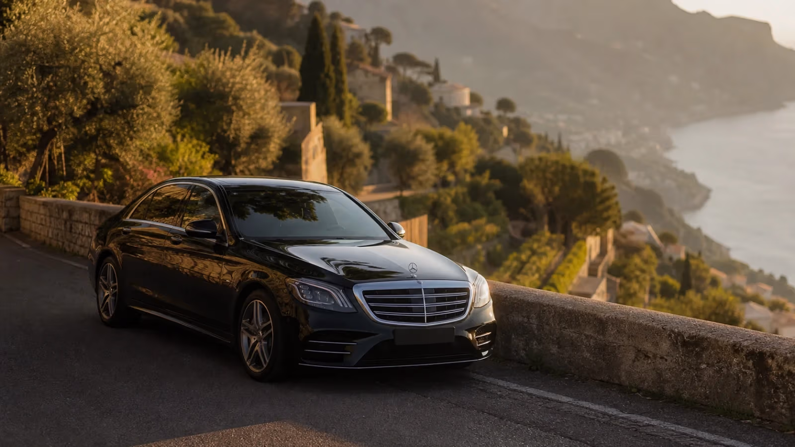 "Auto con autista in attesa lungo una strada di Ravello alta sul mare nel pomeriggio"