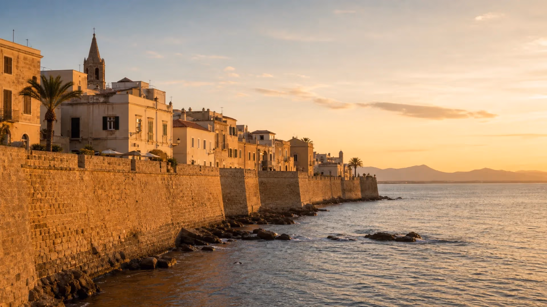 "I bastioni catalani di Alghero affacciati sul mare al tramonto"